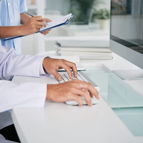 Doctor working on computer Cropped image of doctor working on computer at his table
